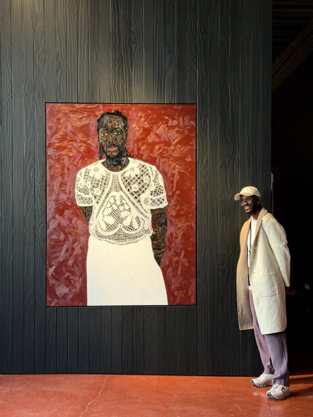 Man beside vibrant portrait on wall